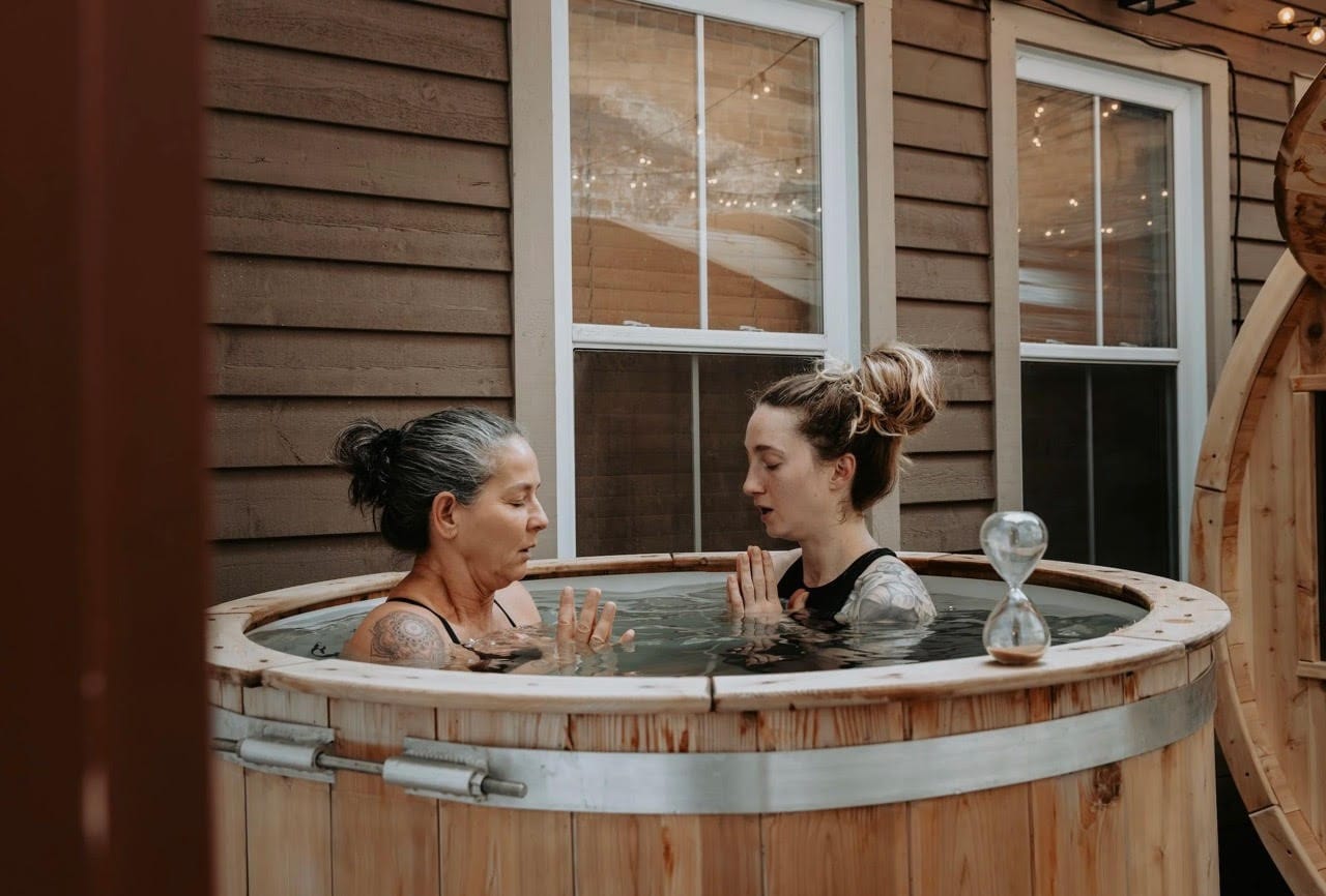 Two women sitting in a cold plunge pool